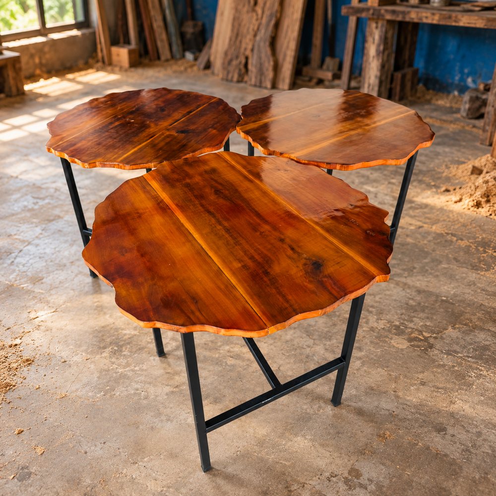 Three finished wooden tables on metal bases